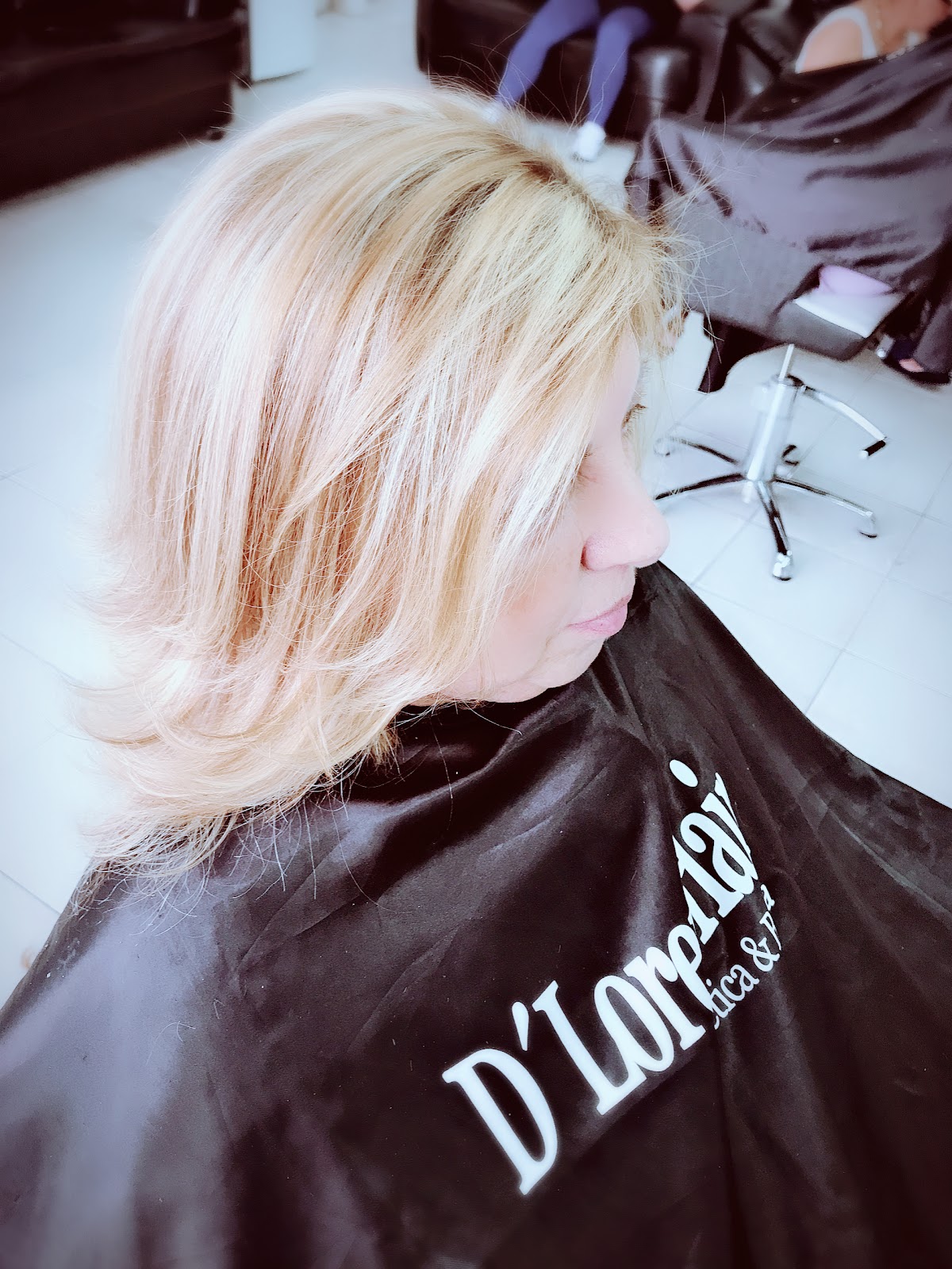 Cliente com a capa do D'Loren Hair durante o atendimento